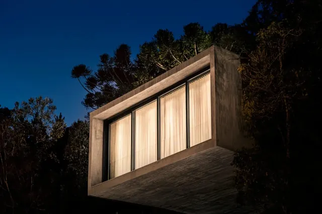 Cantilevered concrete house at night, brutalist, minimal, dark