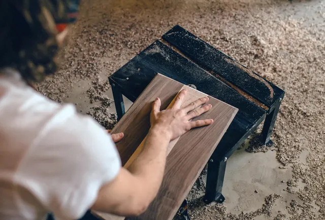 Woodworker routing walnut board, photographic, organic, warm