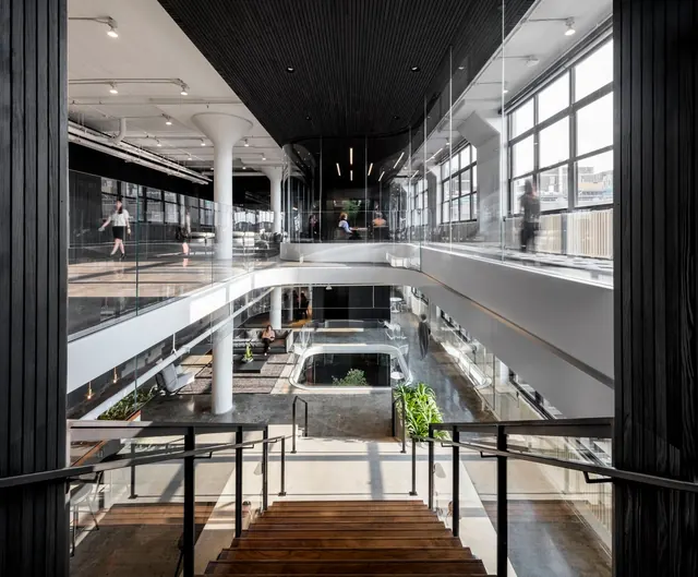 Modern open office atrium with vertical circulation, photographic, corporate-clean, light