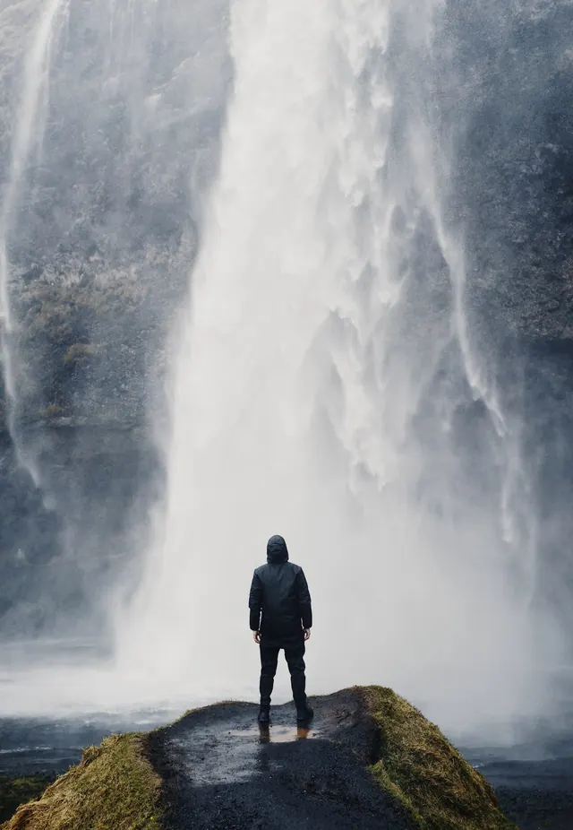 Person Standing Before Waterfall