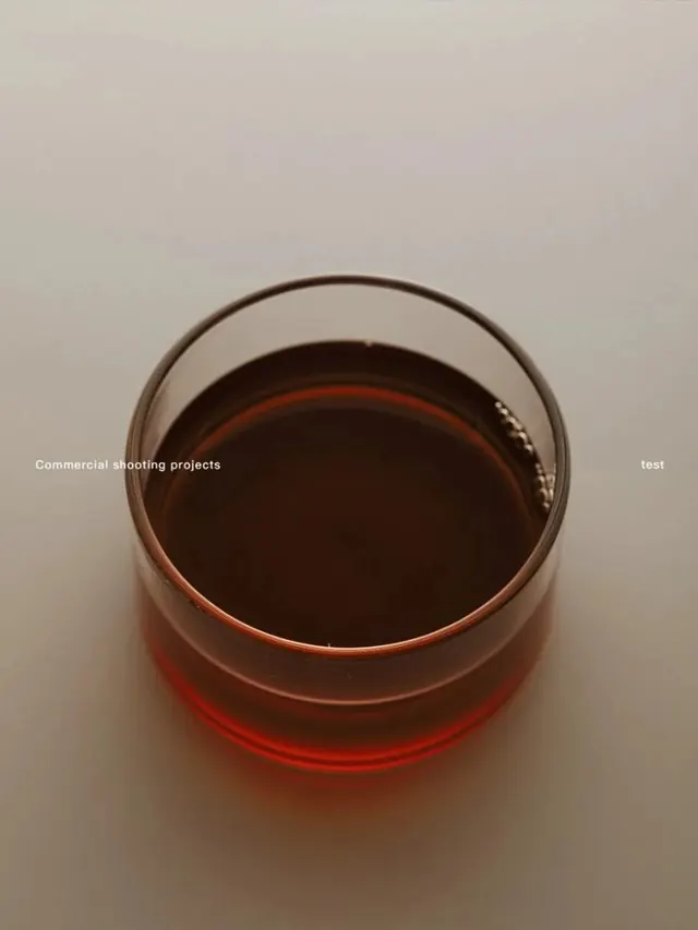 Glass bowl with amber liquid showing liquid gradient, photographic, minimal, warm
