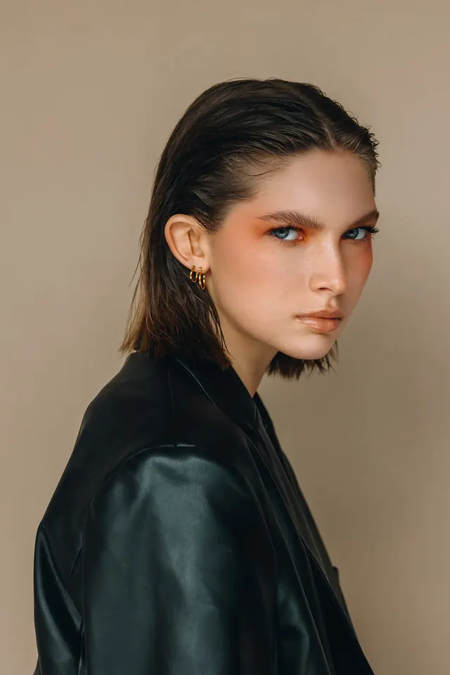 Portrait with heavy orange and teal eyeshadow makeup, photographic, editorial, high-contrast