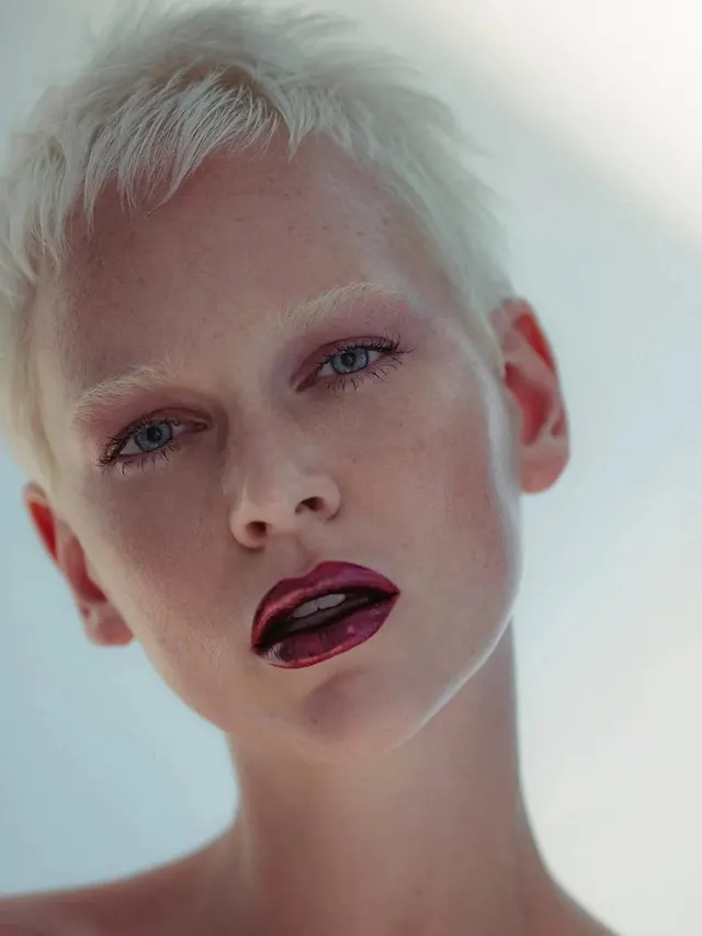 Beauty portrait with bold burgundy lip and short platinum hair, photographic, editorial, muted