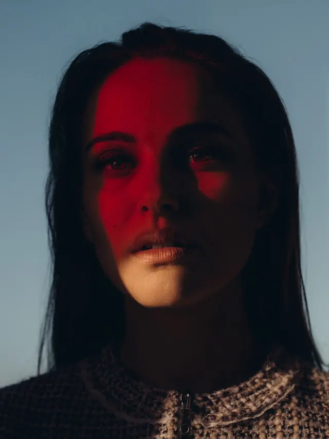 Portrait with red and cool blue split-lighting effect, photographic, editorial, high-contrast