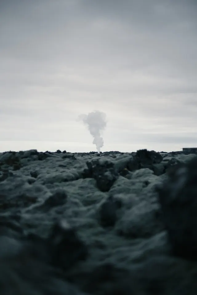 Smoke rising from rocky landscape, photographic, minimalist, muted