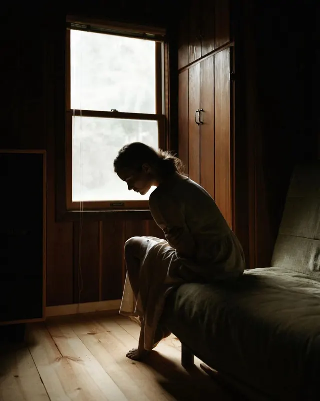 Contemplative interior portrait with natural light, photographic, organic, warm