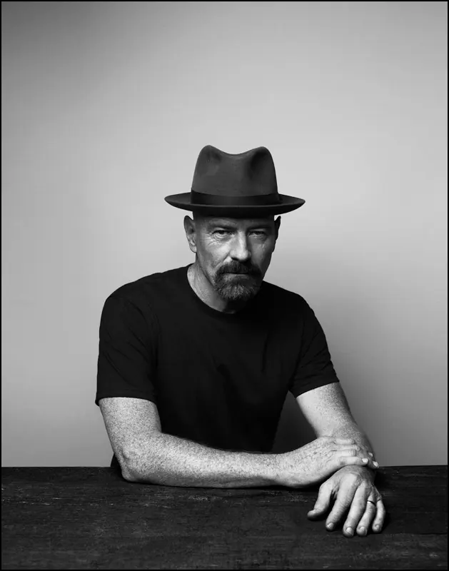 Portrait with fedora and table, photographic, minimal, monochrome