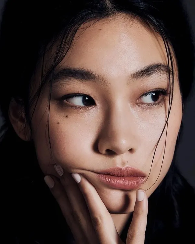 Dramatic beauty portrait with hand pose, photographic, minimal, dark