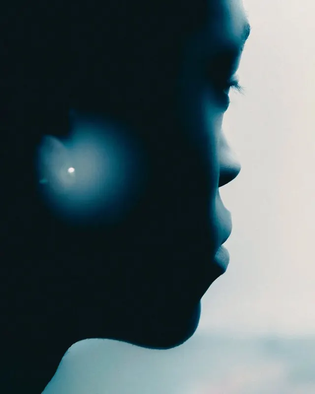 Profile silhouette with blue atmospheric lighting, photographic, minimal, dark