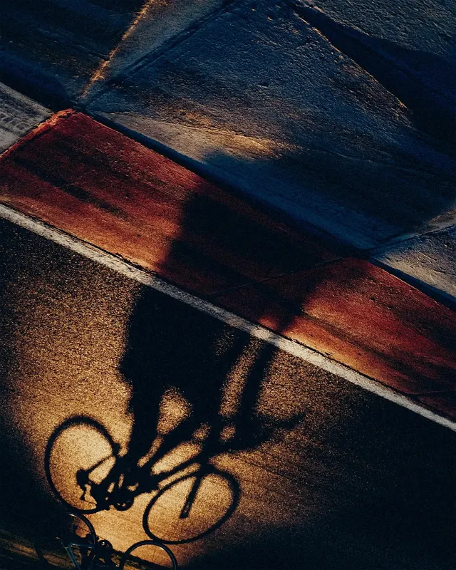 Bicycle shadow with dramatic colored light, photographic, abstract, warm