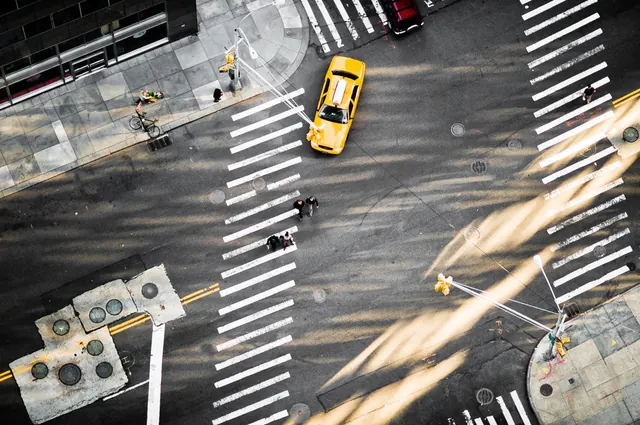 Aerial urban intersection with yellow taxi, photographic, geometric, warm