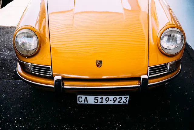 Vintage orange Porsche front hood detail, photographic, luxury, vibrant