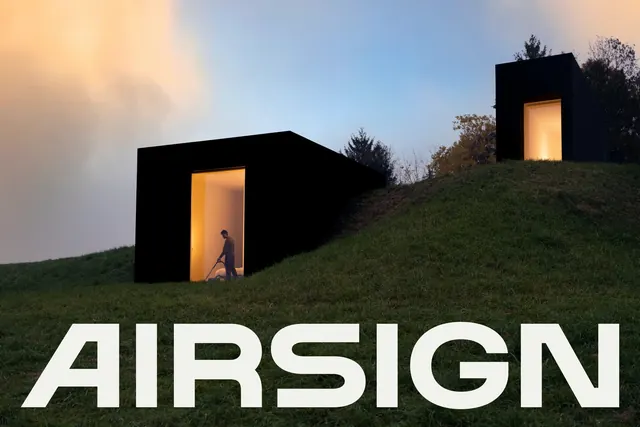 Airsign architectural installation with bold sans-serif type, photographic, minimalist, dark