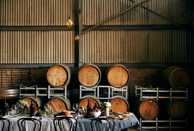 Winery barrel room dinner setup, photographic, luxury, dark