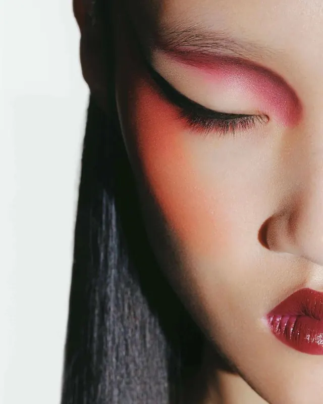 Close-up beauty shot with pink and orange eye makeup, photographic, editorial, warm