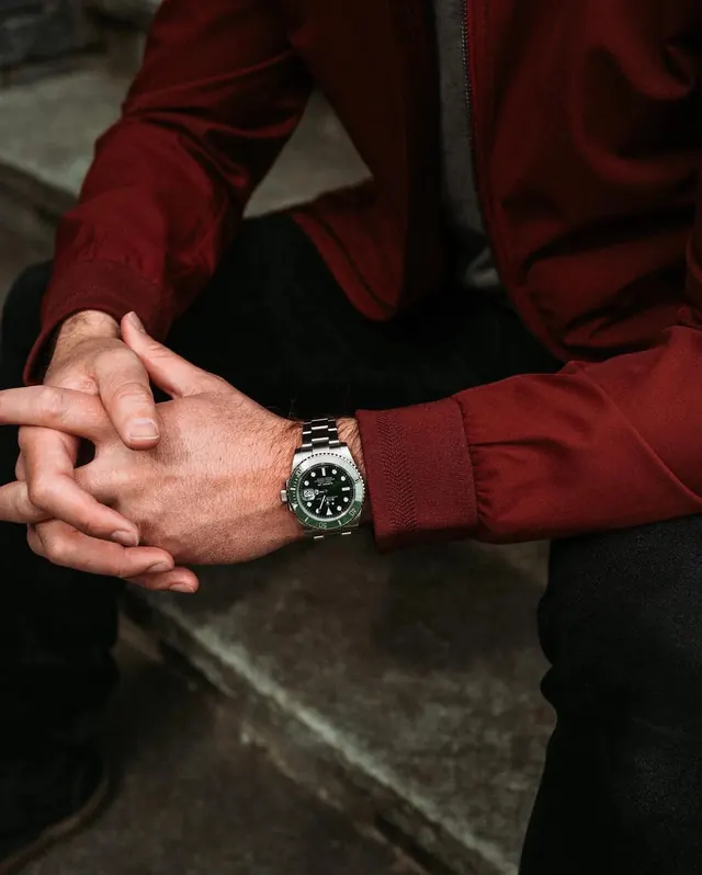Wrist detail with metallic watch, photographic, minimal, warm