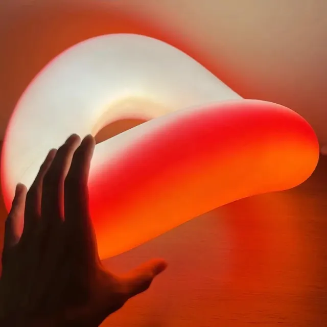 Hand holding illuminated sculptural light, photographic, playful, warm