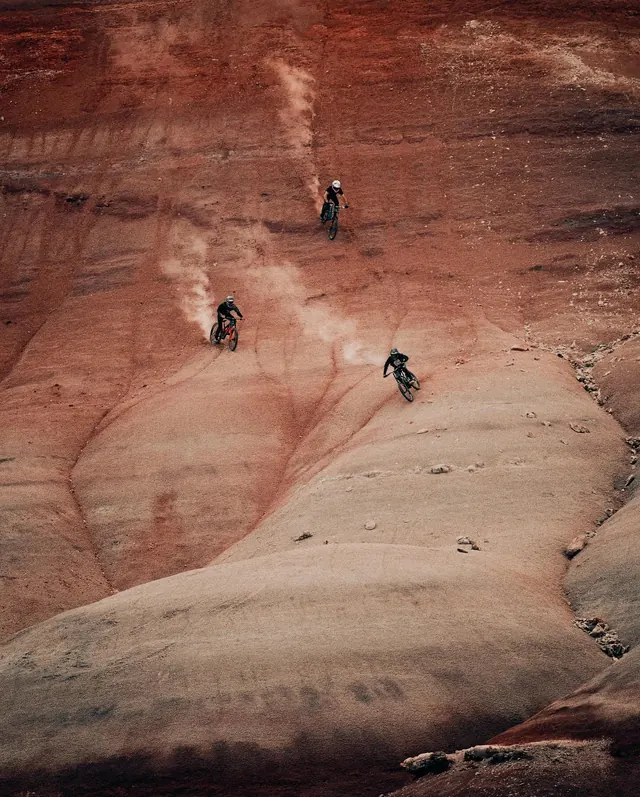 Mountain bikers on red desert terrain, photographic, organic, warm