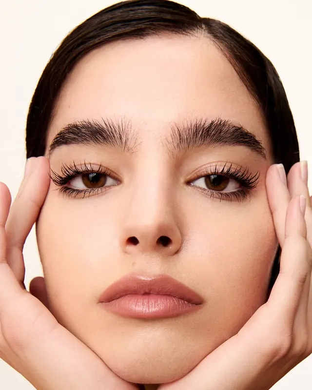 Beauty portrait with peachy tones and closed eyes, photographic, minimalist, warm