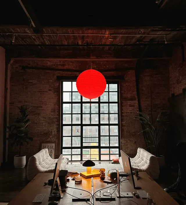 Industrial studio space with red orb and large window, architectural, photographic, warm