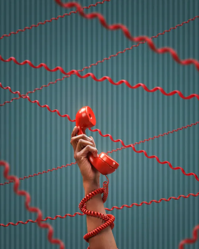 Hand holding red phone with red cables, photographic, styled, vibrant