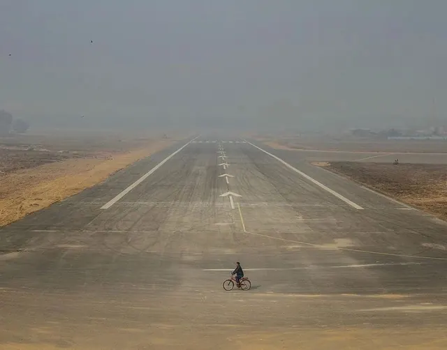 Person on bicycle on empty runway perspective, photographic, minimalist, muted