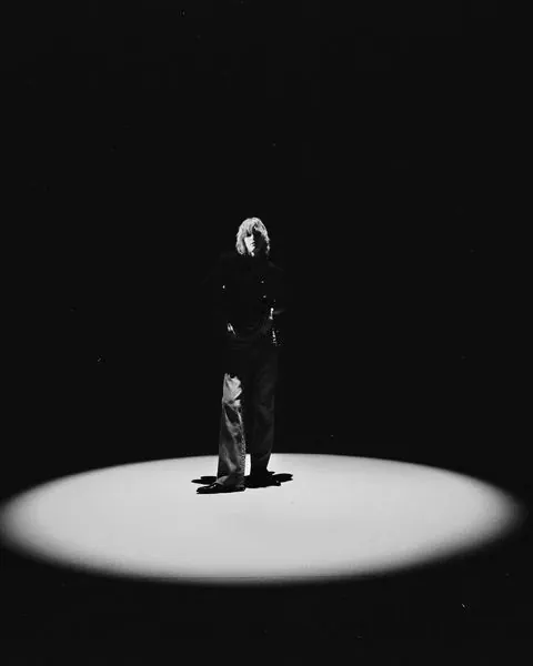 Single figure spotlight portrait, photographic, dark-mode, dark