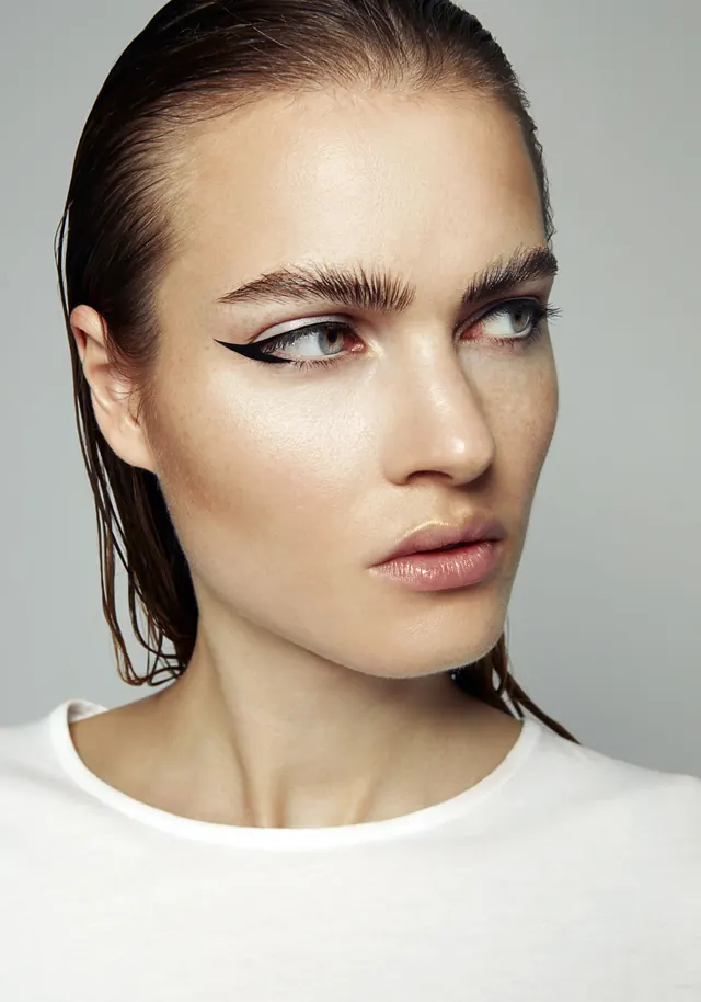 Beauty portrait with graphic eyeliner detail, photographic, minimalist, light