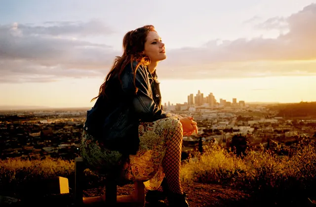 Portrait overlooking urban landscape at sunset, photographic, editorial, warm