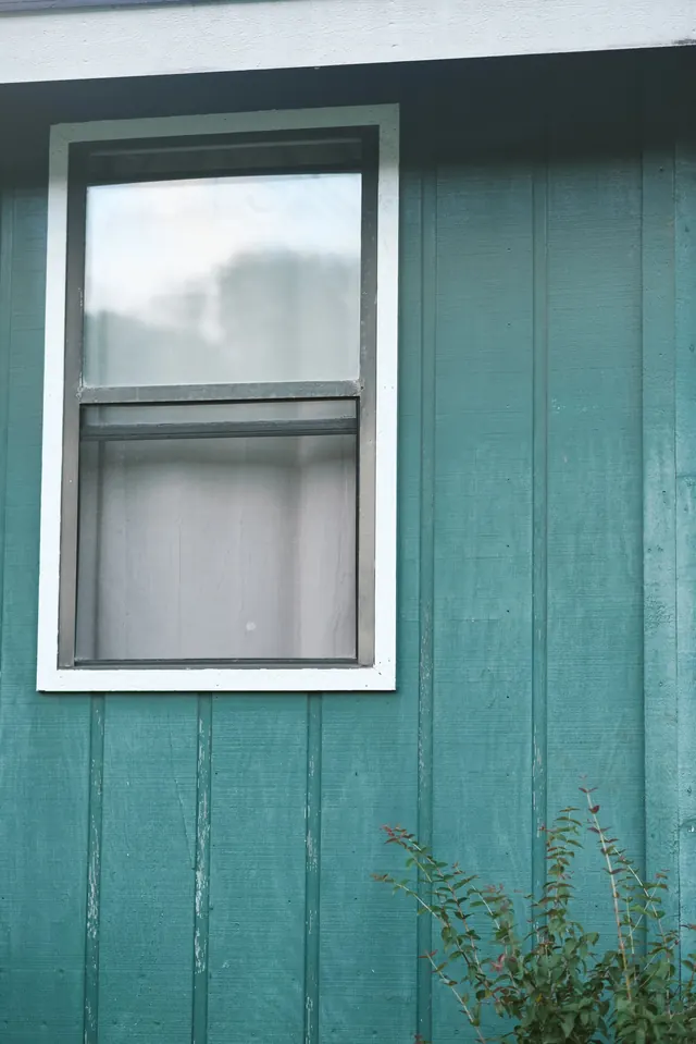 Weathered window on teal wooden wall, photographic, minimalist, cool