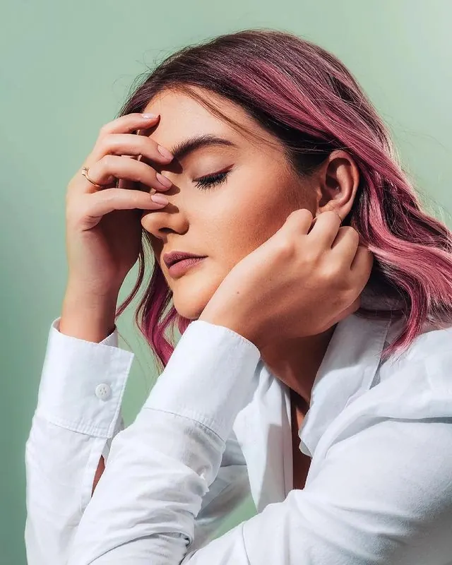 Portrait with pink-toned hair against mint background, photographic, editorial, cool