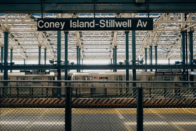 Subway platform with metal beams and signage, photographic, industrial, dark