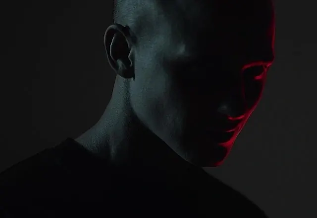 Dark portrait with red and blue split lighting, photographic, dark-mode, dark