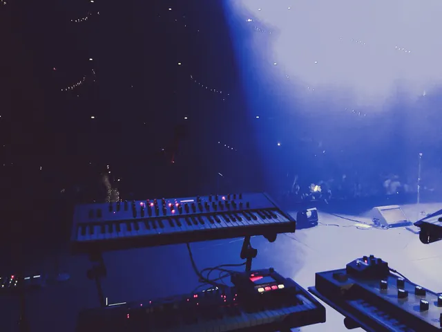 Stage keyboard player performing under blue stage lights, photographic, dark-mode, dark