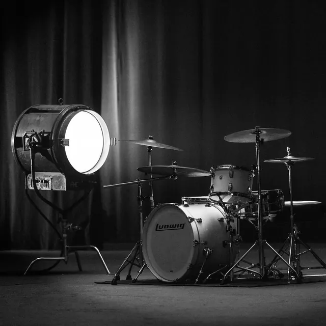 Stage drum kit with theatrical lighting, photographic, technical, monochrome