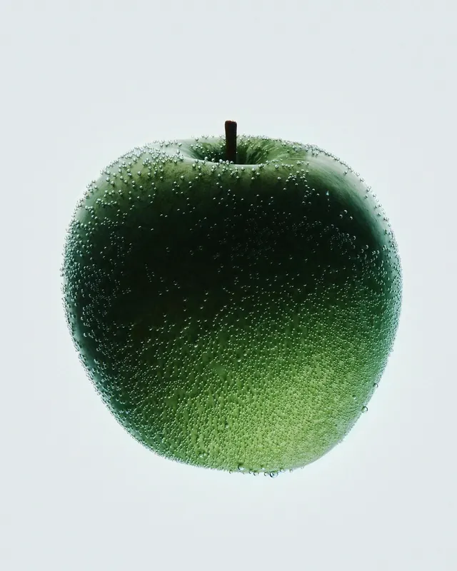 Green apple with water droplets, photographic, organic, cool