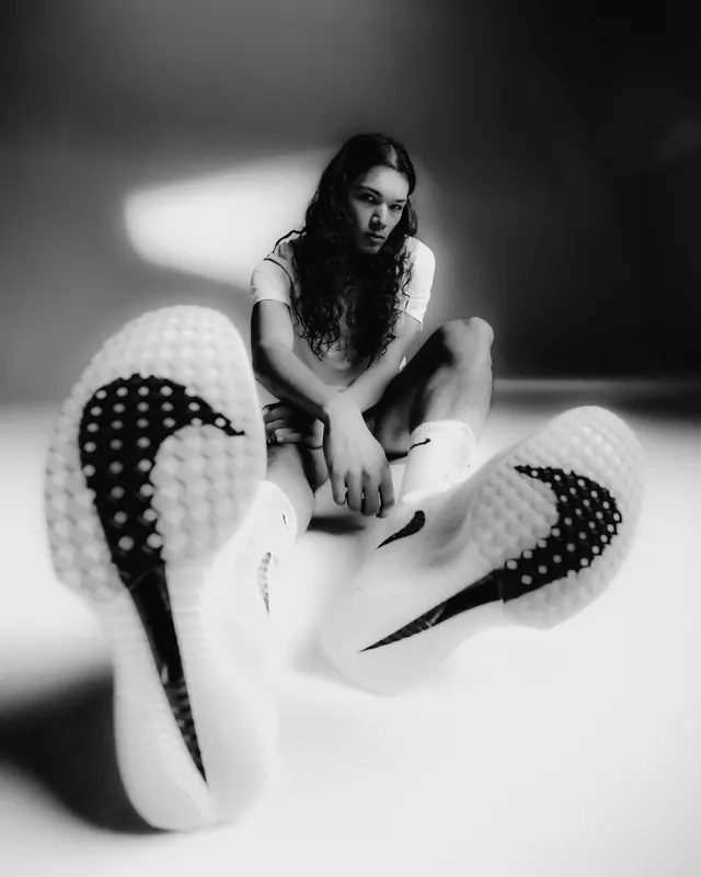 Fashion portrait with oversized shoes, photographic, editorial, monochrome