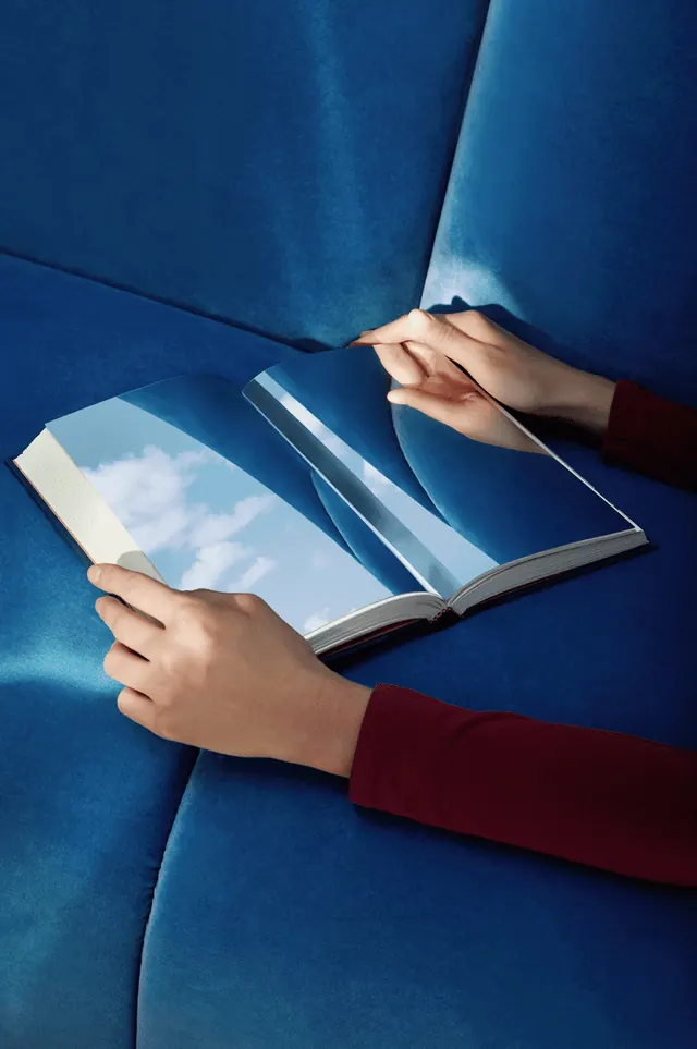 Magazine reading photograph with blue fabric, photographic, editorial, cool