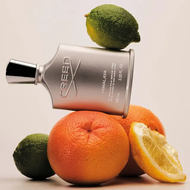 Fragrance product photography with citrus fruits, photographic, editorial, warm