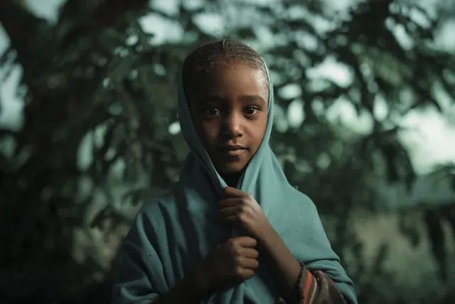 Portrait of a person in a blue hood