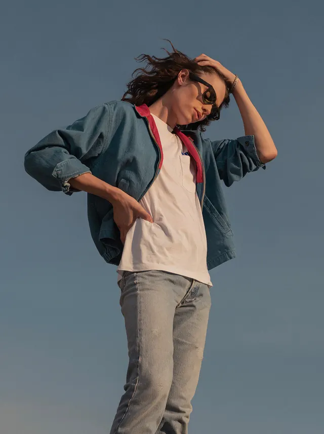Portrait of a person in denim and sunglasses