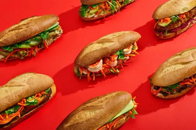 Assorted banh mi sandwiches on red, photographic, minimal, vibrant
