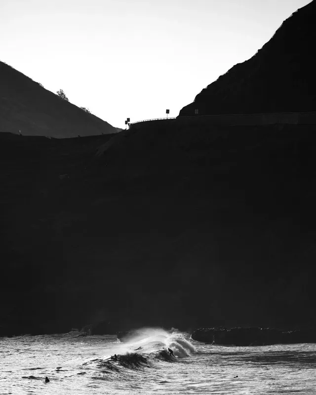 Black and white surfer on crashing wave, photographic, monochrome, dark