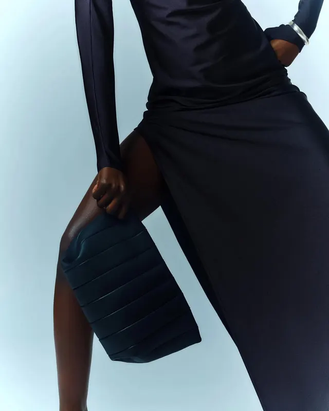 Fashion model in navy dress with pleated bag, minimal, luxury, dark