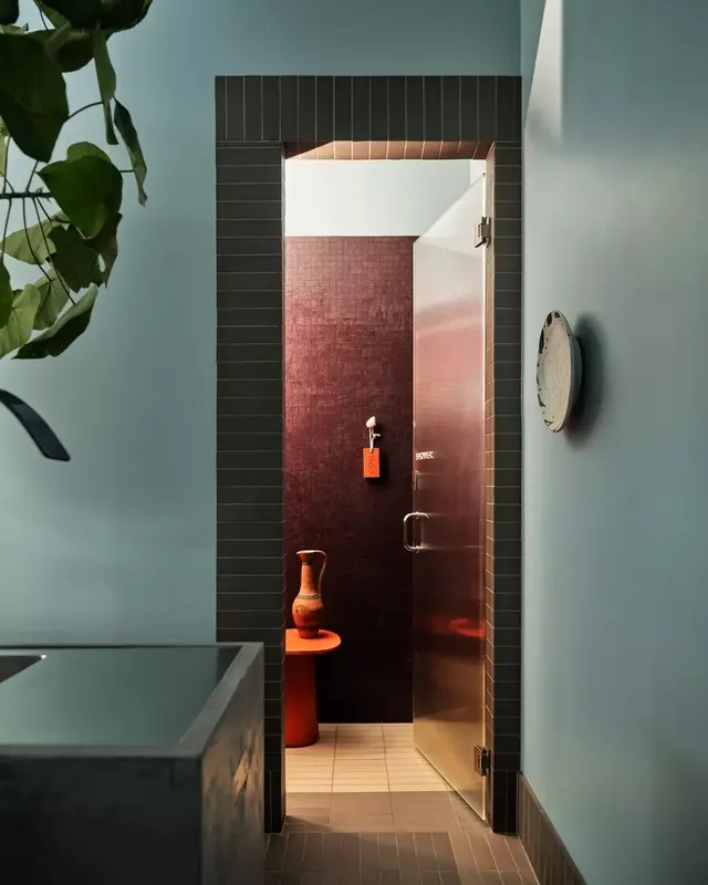 Bathroom interior with framed red shower and terracotta accents, minimal, photographic, muted