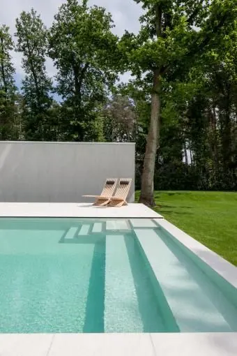 Modern outdoor swimming pool with lounge chairs, photographic, minimal, light