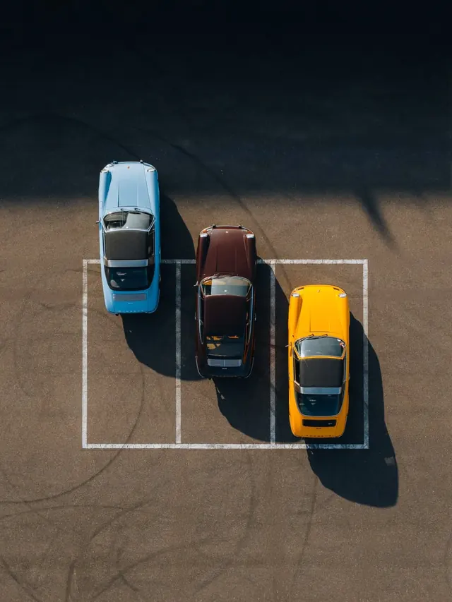 Aerial view of three classic cars in parking spaces, photographic, dark