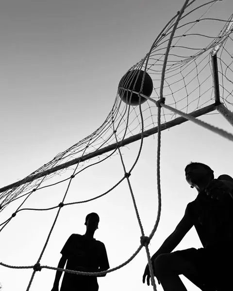 Low-angle silhouette soccer goal with ball and players, photographic, monochrome, monochrome