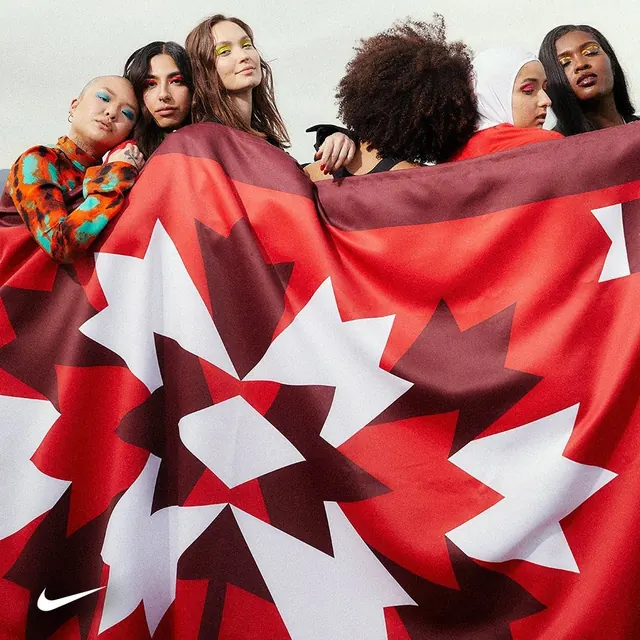 Diverse models wrapped in bold red graphic flag, photographic, editorial, vibrant