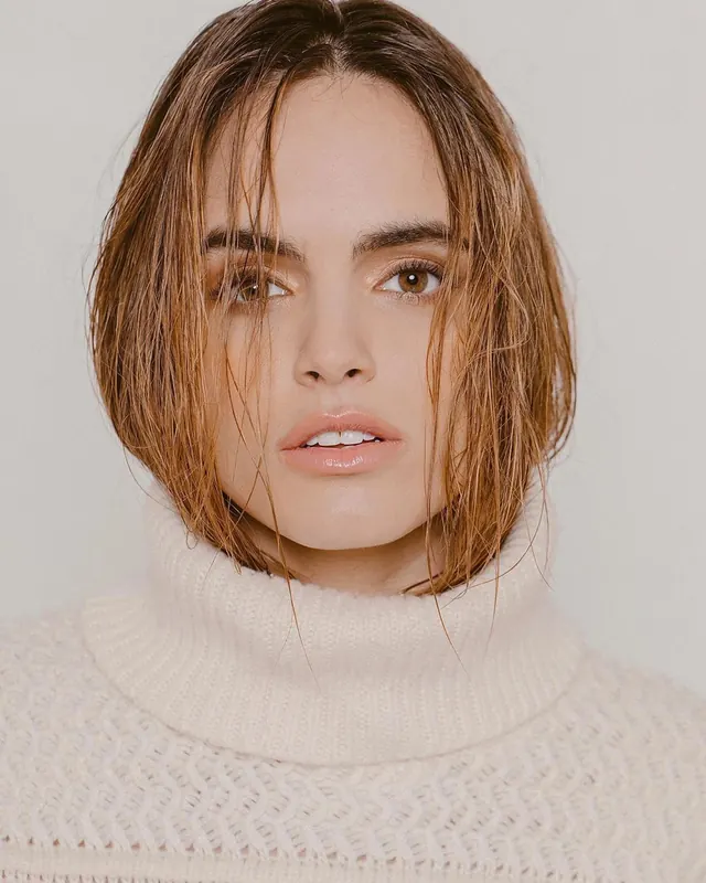 Close-up portrait of woman in white turtleneck, minimal, photographic, muted